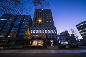 Een modern hotelgebouw met meerdere verdiepingen, grote ramen en een opvallende ingang.