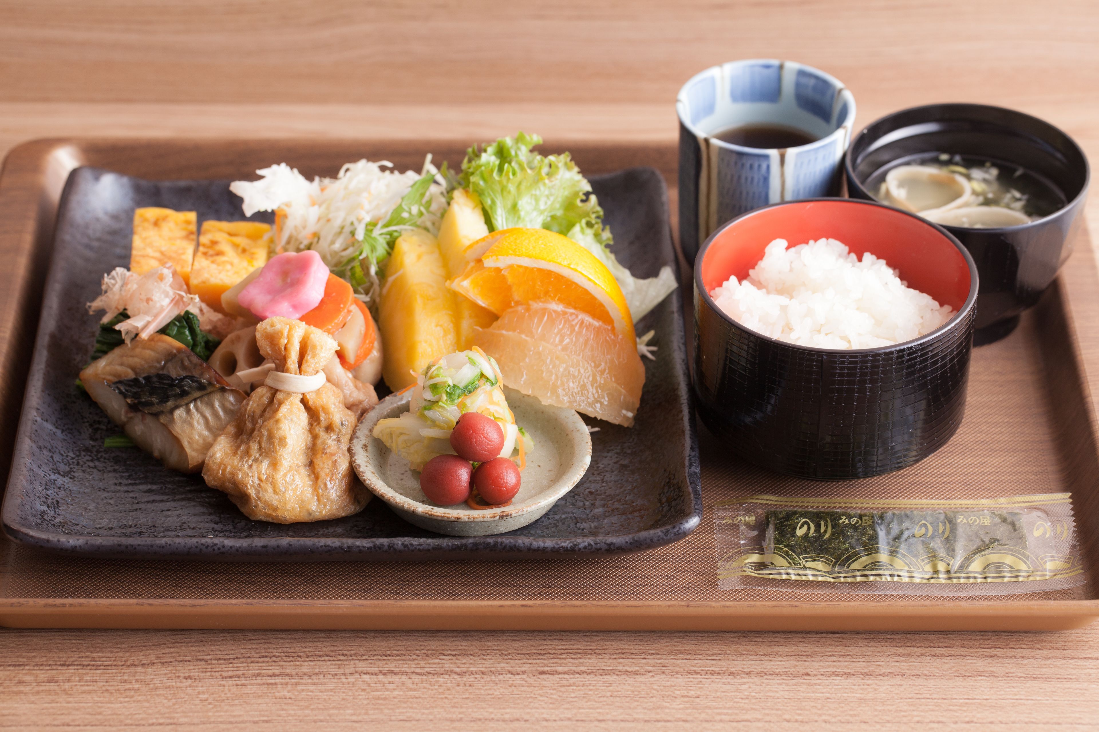 Una comida tradicional japonesa con diversos platos y acompañamientos en una bandeja.