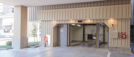 Entrada moderna de un edificio con rampa y extintor.