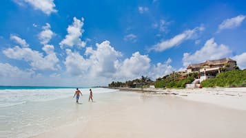 Na praia, areia branca, toalhas de praia