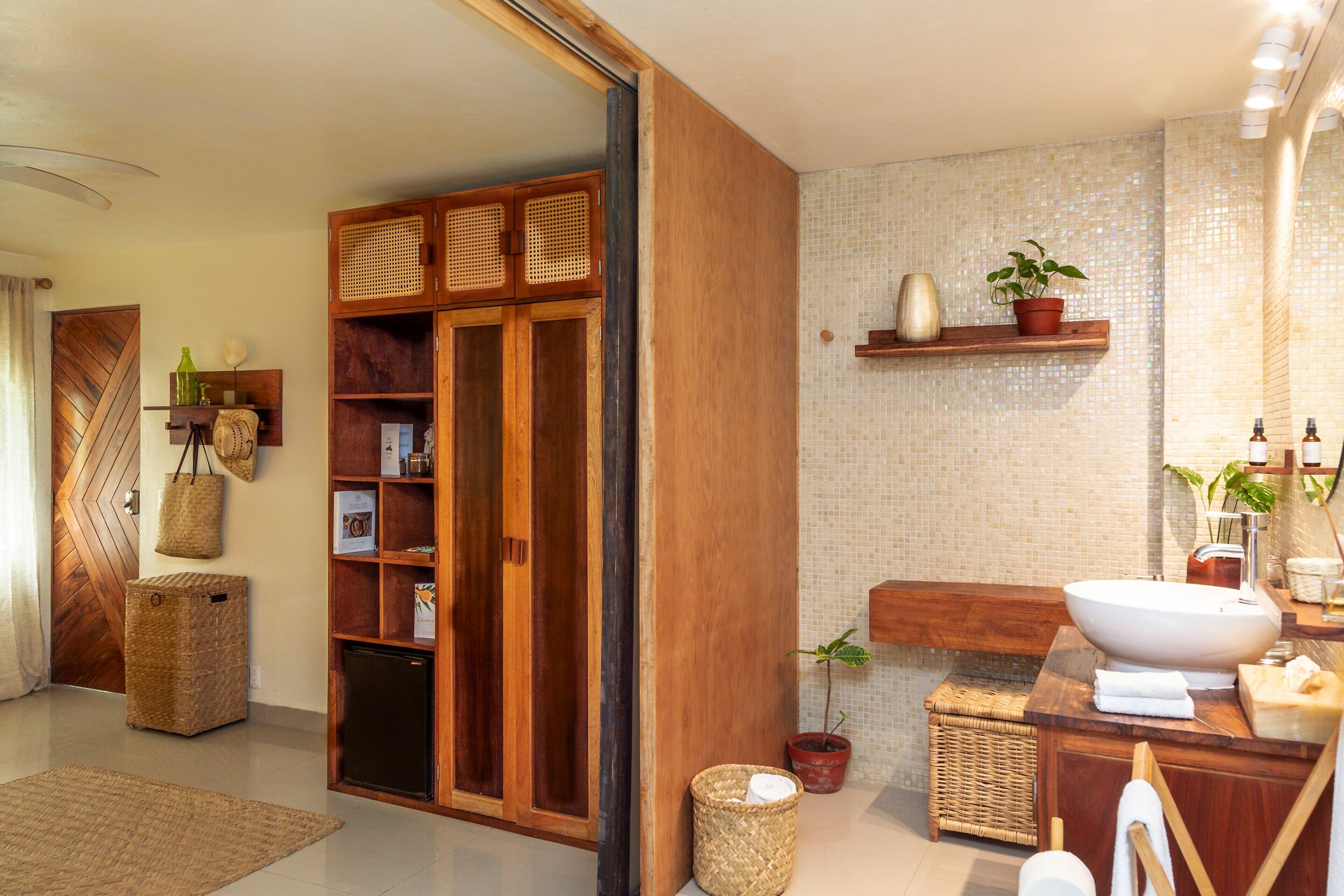 A modern bathroom with a large wooden cabinet, a white sink, and a mirror.