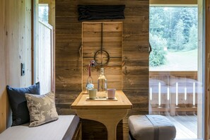 A wooden room with a bench, a table with a bottle, glasses, and a cup. - mama thresl (Leogang)