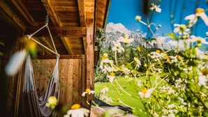 A wooden cabin with a hammock and a view of a mountain and garden. - mama thresl (Leogang)