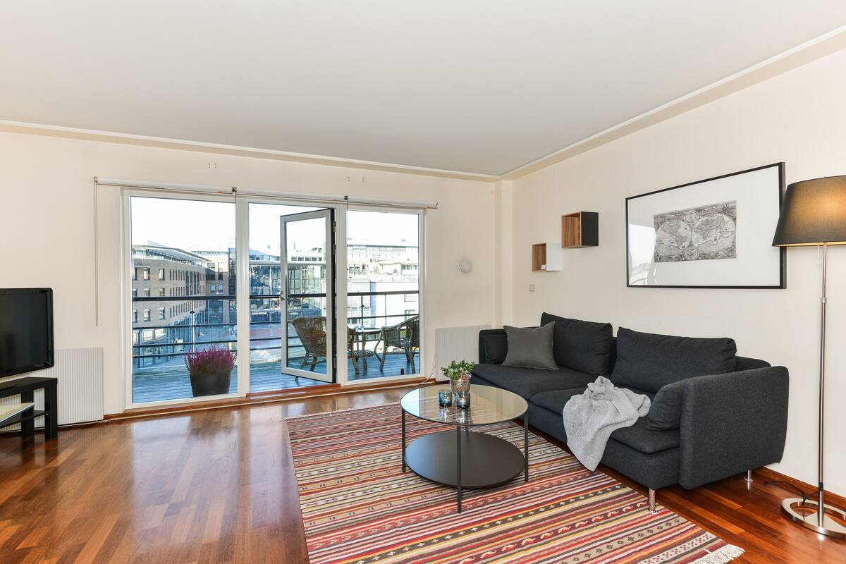 A modern living room with a sofa, a coffee table, and a TV.