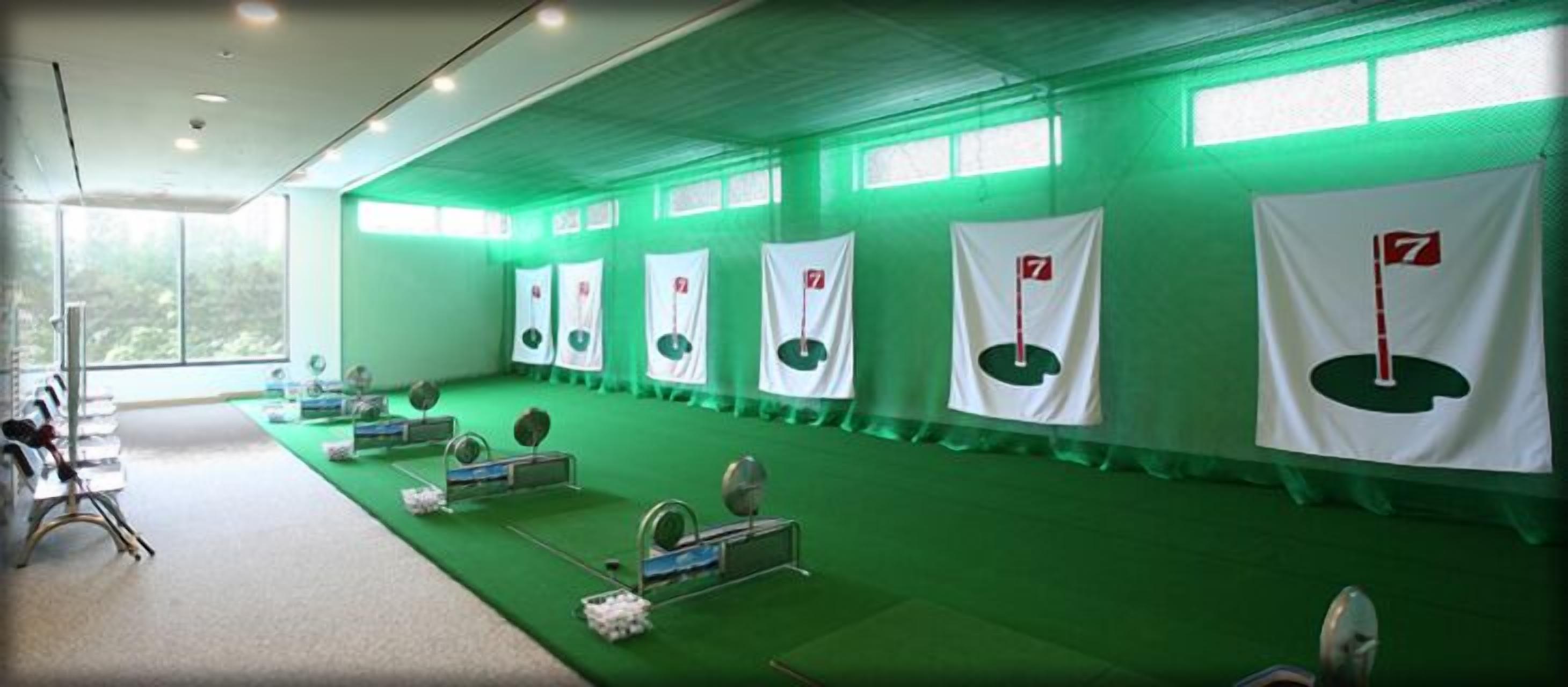 A gym with green walls, white banners, and exercise equipment.