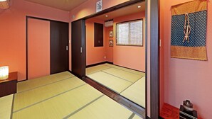Una habitación japonesa tradicional con suelo de tatami, puertas correderas y un celosía de papel.