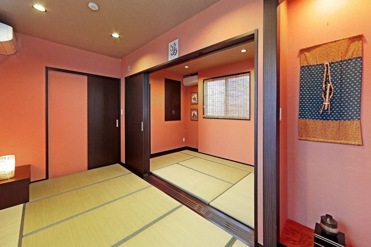 Une pièce de style japonais traditionnel, avec un sol recouvert de tatamis, des portes coulissantes et un paravent shoji.