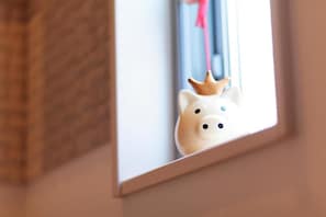 A piggy bank with a crown on a window sill.