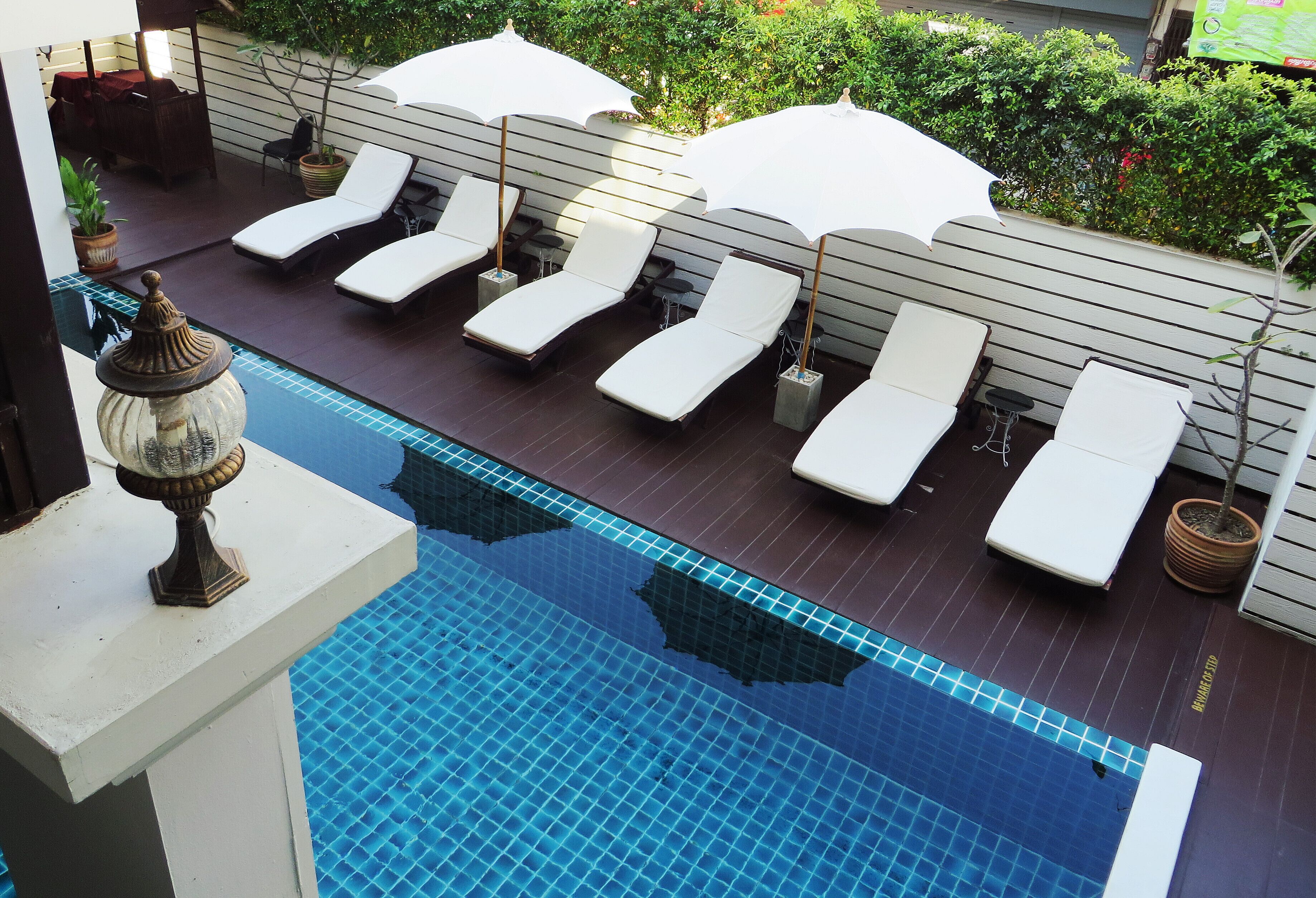 A rooftop pool area with lounge chairs and umbrellas.