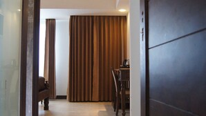 Ein Hotelgang mit Holztür, einem Esstisch und einem Stuhl.