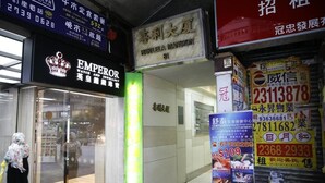 Une devanture de magasin avec une enseigne indiquant « Barilela Mansion » et une autre indiquant « Emperor Watch & Jewelery ».