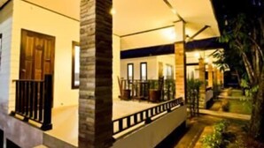 A modern house with a covered porch, a stone pillar, and a wooden door. - Thalane Resort (Krabi)