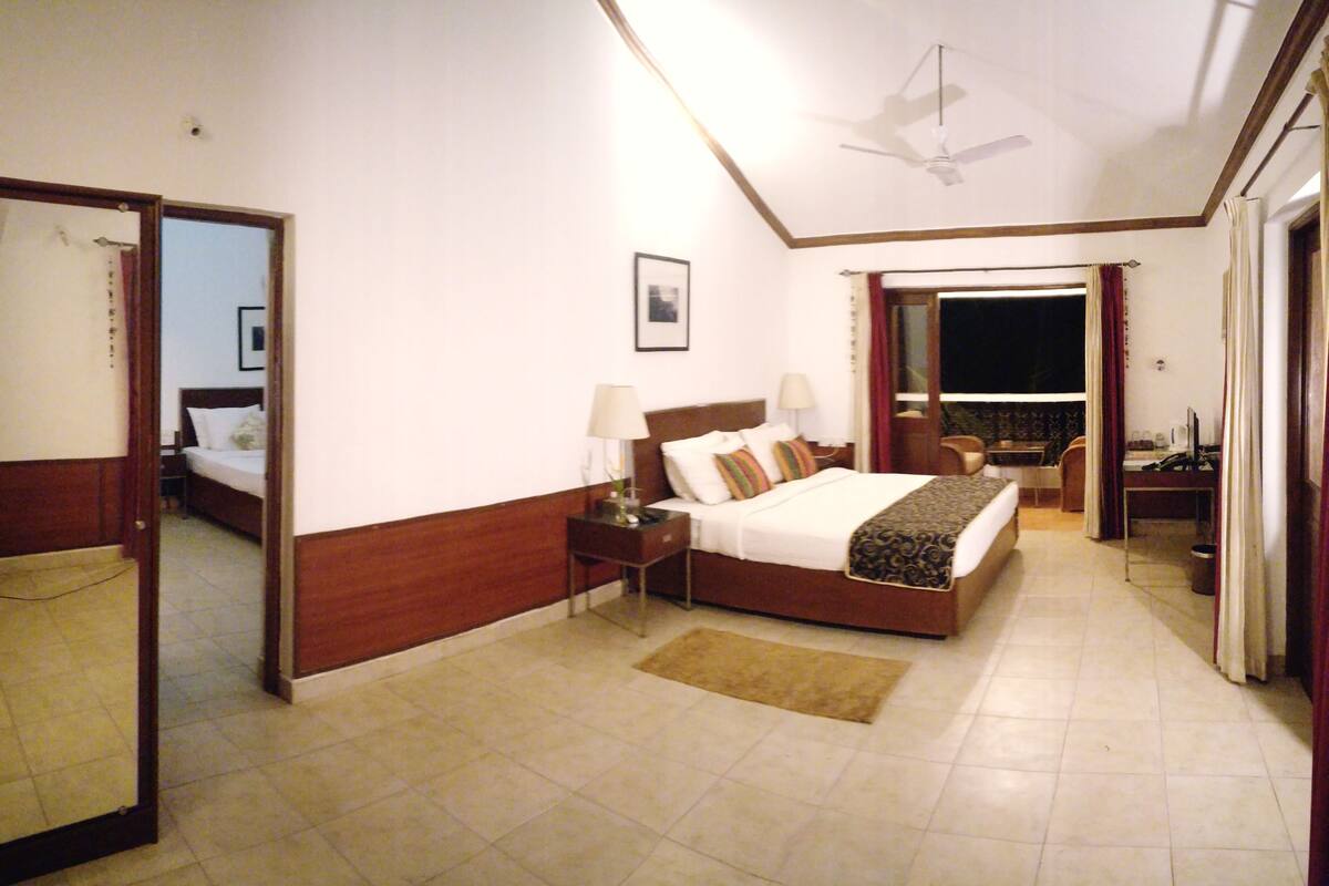A bedroom with a bed, nightstand, and a mirror.