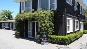 En sort bygning med hvide detaljer og et skilt, der viser 'The Lake Retro Studio', tilgængelig nu.