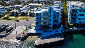 A waterfront hotel with multiple balconies, a dock, and a clear view of the water. - Tripcony Quays Apartments (Caloundra)