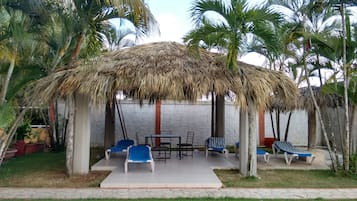 Una piscina al aire libre, sillones reclinables de piscina