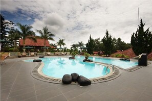 Una piscina al aire libre, sillones reclinables de piscina