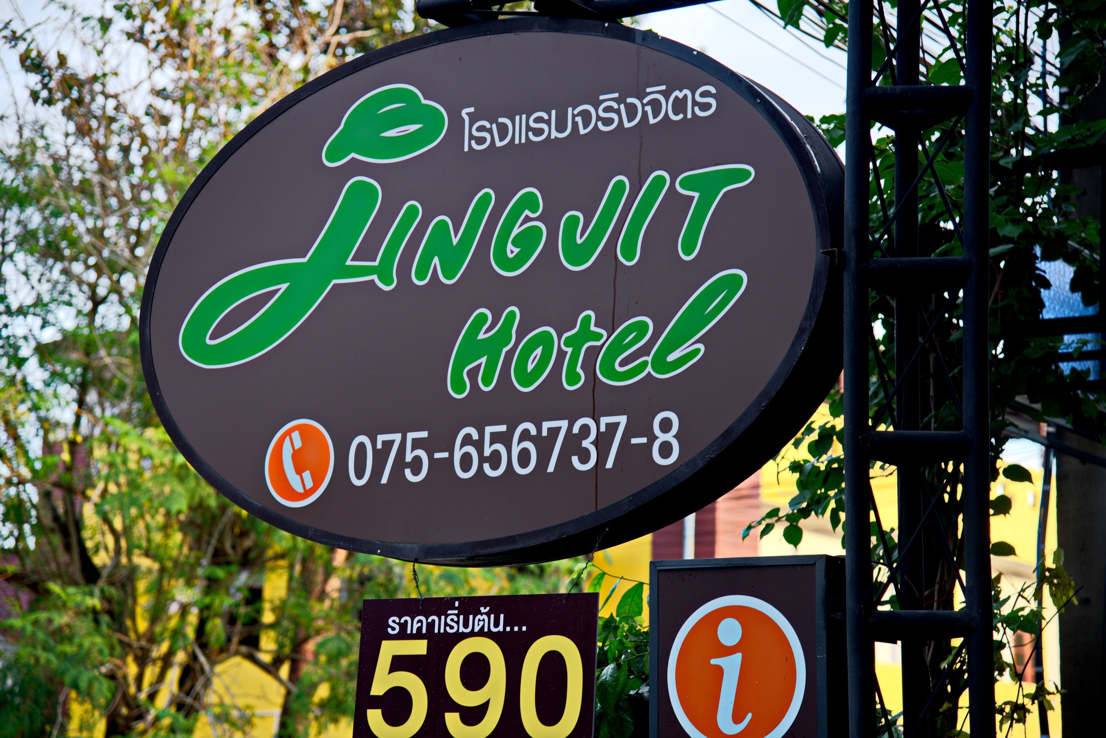 A sign for Jingjit Hotel with a contact number and a price tag.