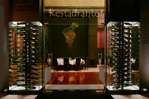 A restaurant entrance with a wine rack display and a dining area visible inside. - Complejo Enoturístico Finca La Estacada (Tarancon)
