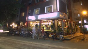A multi-story building with a ground-floor restaurant and several parked motorcycles. - Royal Shades (Bengaluru)