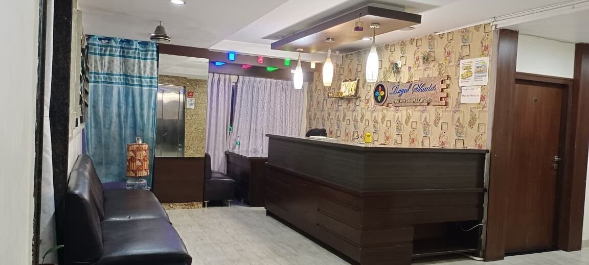 A reception area with a wooden reception desk, a black leather sofa, and a water dispenser.