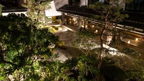 A traditional Japanese-style building with a courtyard, surrounded by trees and featuring a stone pathway. - Hagi No Yado Tomoe (Hagi)
