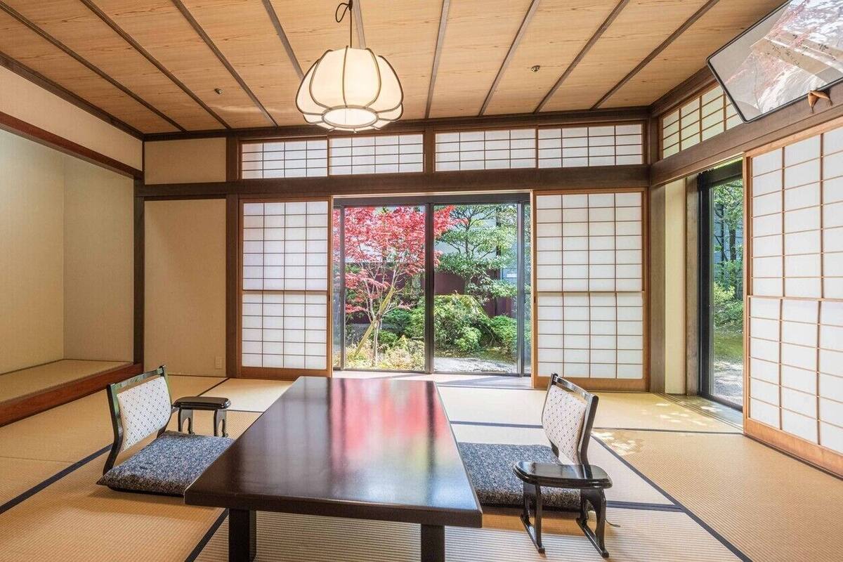 A traditional Japanese room with tatami flooring, a low table, and shoji screens.