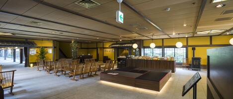 A spacious lobby with a reception desk, seating area, and a fireplace.