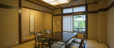 A traditional Japanese room with tatami flooring, a low table, and sliding doors.
