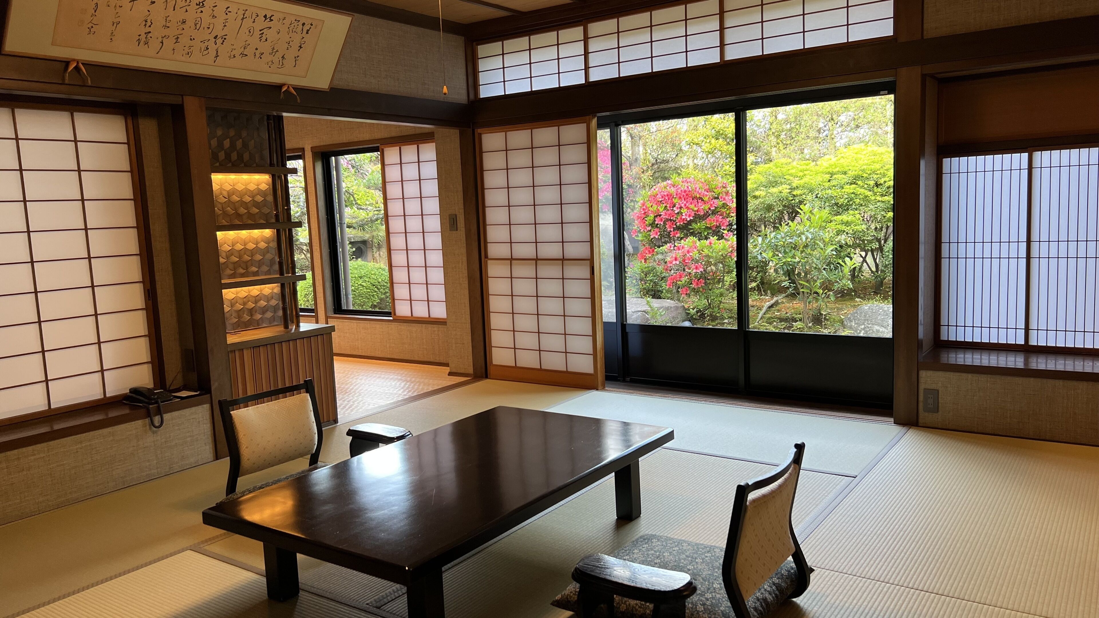 A traditional Japanese room with tatami flooring, a low table, and shoji screens.