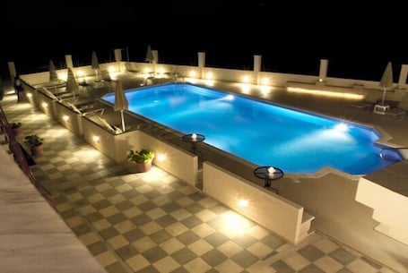 Una piscina al aire libre de temporada, sombrillas