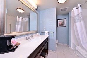 A modern bathroom with a double sink, a large mirror, and a shower area.