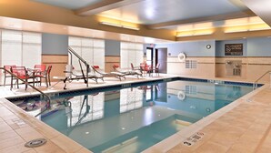 Una piscina interior con sillas de descanso y una estación de socorristas.