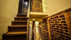 A staircase with a metal handrail and a brick wall on one side. - Hôtel Hors Château (Liege)