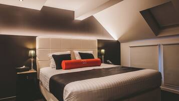 Una habitación de hotel moderna con una cama grande, un tragaluz y vistas a la ciudad.