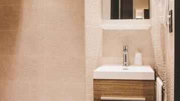 Un baño moderno con ducha, lavabo e inodoro.