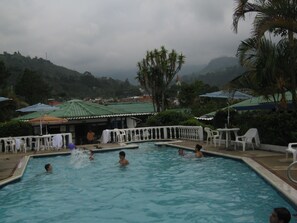 Piscine extérieure, piscine avec cascade, chaises longues
