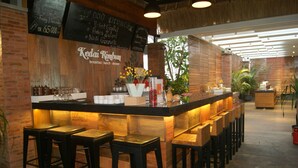 A bar area with a wooden counter, stools, and a chalkboard menu.