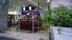 A restaurant with a bar area, indoor plants, and a stone wall. - Hotel Restaurant Hamilton (Boca Chica)
