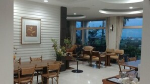 Una sala de estar moderna con comedor, ventanas amplias y vistas al exterior.
