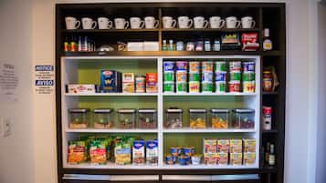 A self-service beverage and snack station with various drinks, cereals, and snacks.
