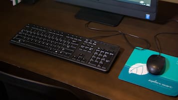 Monitor de computador sobre uma mesa, com teclado e rato.