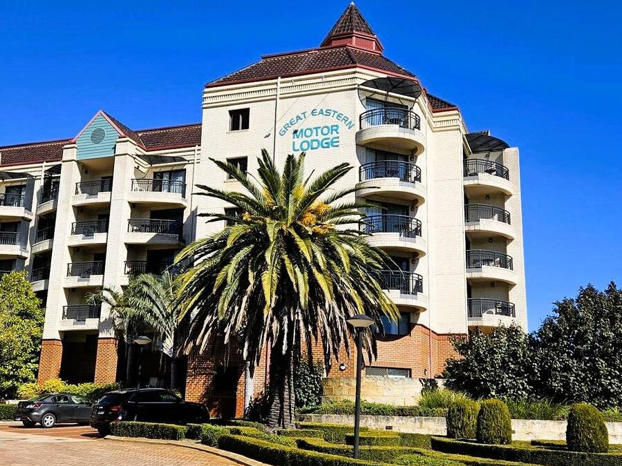 Un edificio de varios pisos con un letrero que dice 'Great Eastern Motor Lodge'.