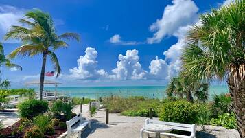 PĂ„ stranden, vit sandstrand och solstolar
