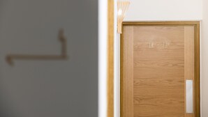En dörr av trä med en metallplatta och en liten lampa monterad ovanför.