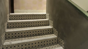 A staircase with checkered tile steps leading up to a landing. - Mingle Place by The Park (Hong Kong)