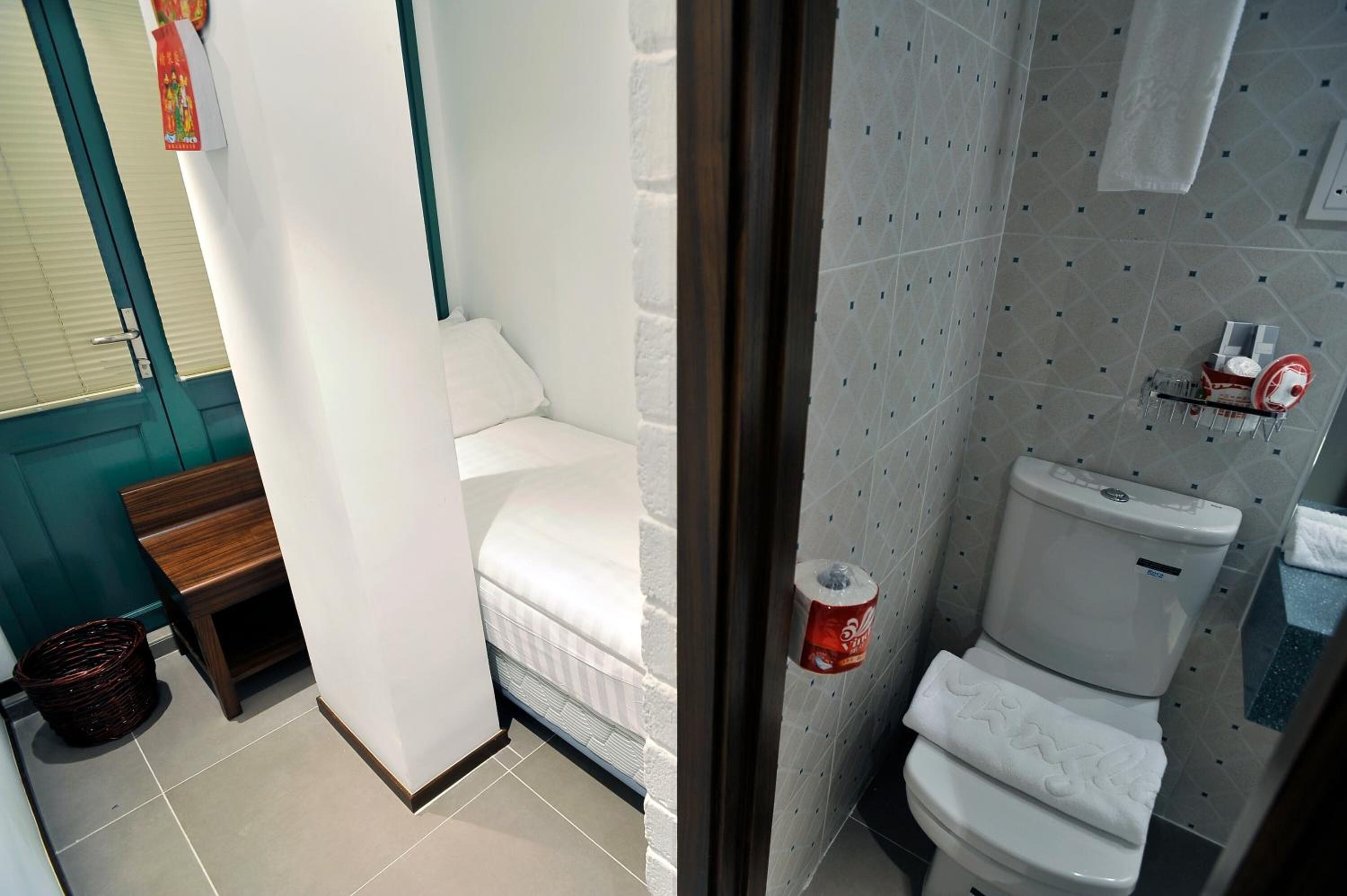 Une salle de bain comprenant des toilettes, une petite étagère avec des articles de toilette et un espace douche.
