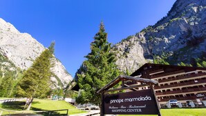 Señalización de 'Principe Marmolada Wellness - Bar - Restaurante Shopping Center' con telón de fondo montañoso.