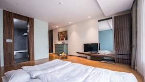 A modern hotel room with a large bed, a television, a desk, and a wardrobe. - Hotel Leo (Jeju City)