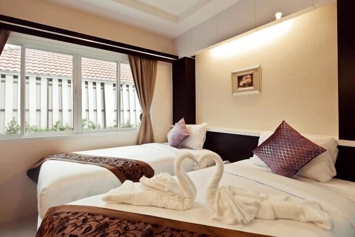 Habitación de hotel con una cama grande, una ventana con cortinas, un cabecero y un cuadro enmarcado en la pared.